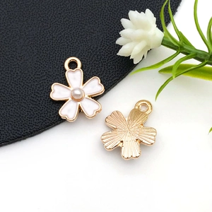 Vue détaillée avant et arrière de breloques fleurs en émail blanc avec perles pour DIY