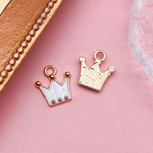 Détail de breloques couronnes en émail blanc et placage doré pour bijoux DIY
