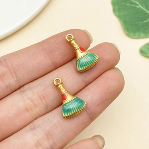 Macro view of gold broom charms with colorful enamel for DIY jewelry making