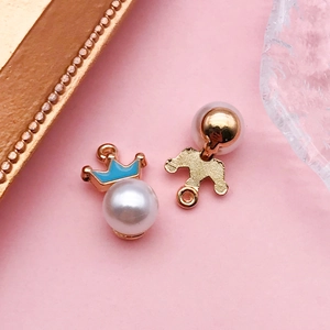 Détail du pendentif couronne plaqué or avec émail bleu et incrustation de perle blanche