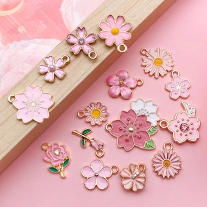 Detail showing pink and white floral enamel charms with gold edges for DIY jewelry