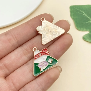 Detail of enamel rice dumpling charm with I CAN DO IT text and gold metal plating