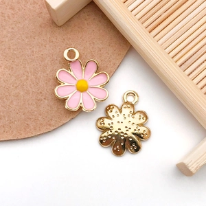 Close-up of pink and yellow daisy flower pendants for DIY jewelry making