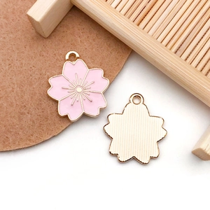 Macro shot of pink cherry blossom pendants with golden metal texture and petal details