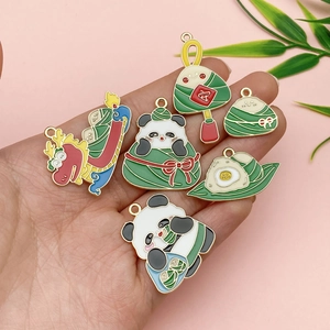 Detail of colorful enamel dragon boat and panda rice dumpling charms on hand