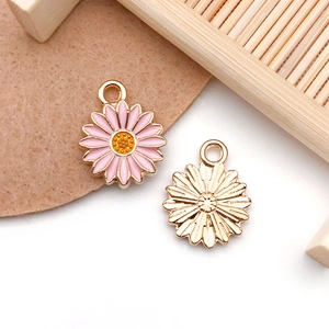 Detail of pink daisy flower charms with gold accents for DIY jewelry and necklaces
