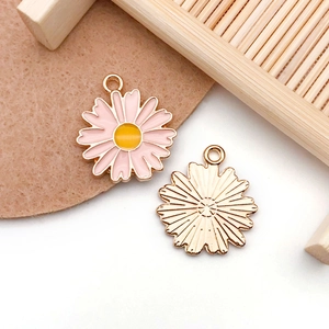 Detail of pink enamel daisy flower charms with gold textured back for DIY jewelry