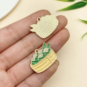 Macro shot of enamel panda zongzi charm with green bamboo basket detail and gold mesh back