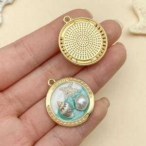 Macro detail of ocean-themed charm showing golden starfish and pearls on sea-blue resin