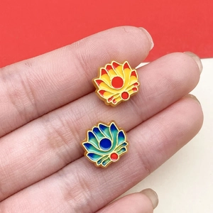 Detailed macro view of enamel lotus charms in red and blue with gold trim details