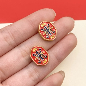 Detailed close-up of traditional Chinese cloisonné lotus beads with red enamel and gold trim