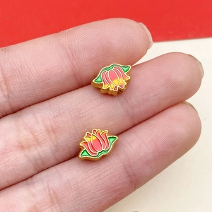 Detailed view of handmade enamel lotus beads for DIY jewelry making held in hand