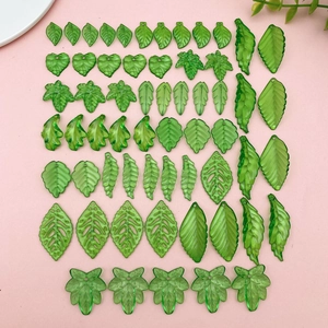 Flat lay of green acrylic leaf pendants in various shapes for DIY jewelry making