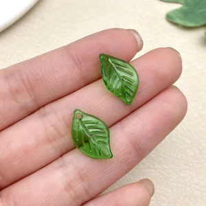 Detail of green acrylic leaf pendants with vein texture and pre-drilled holes for DIY