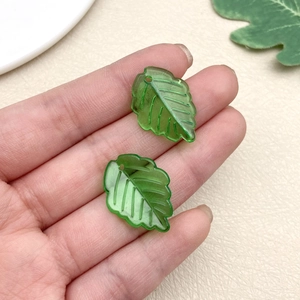 Detail of green acrylic leaf pendants with vein patterns for handmade earring DIY projects