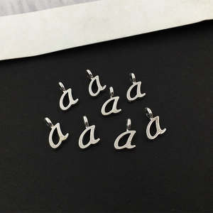 Makroaufnahme von silbernen kleinen Buchstaben-a-Anhängern für DIY-Schmuck
