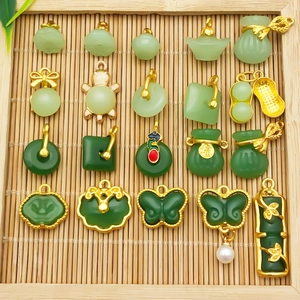 Detailed macro of assorted faux jade pendants with gold metal frames and tassels