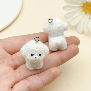 Close-up of two white flocked Bichon puppy charms with silver metal rings for DIY jewelry
