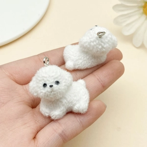 Close-up of white flocked puppy charms with soft furry texture and silver metal rings