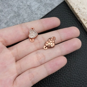 Macro view of rose gold heart-shaped magnetic clasp with inset crystals for jewelry making