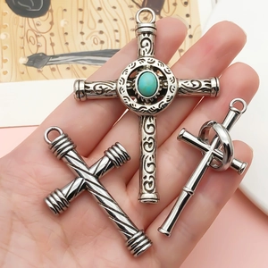 Trois pendentifs croix vintage avec incrustation turquoise et spirales en main