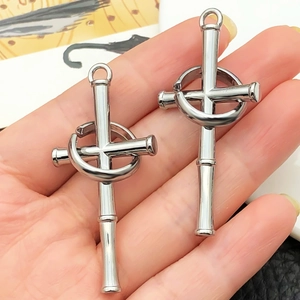 Détail d'un pendentif croix en métal avec texture bambou et anneau mobile pour bijoux DIY
