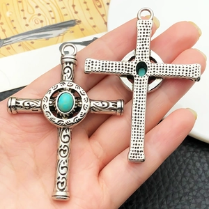 Détail du pendentif croix en argent vintage avec pierre turquoise et gravures ornées