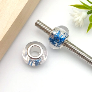 Close-up of blue glitter resin beads with silver metal cores for DIY charm bracelets