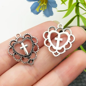 Gros plan sur des pendentifs vintage en forme de cœur croisé en argent pour bijoux DIY
