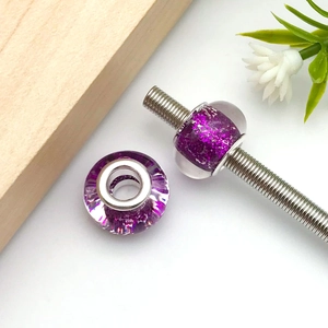 Detailed macro view of purple glitter resin large hole beads with silver metal core