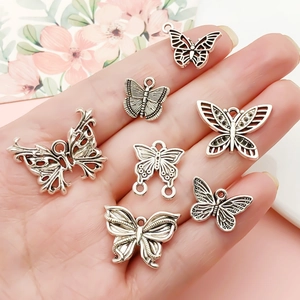 Set di sette ciondoli a farfalla in argento vintage per gioielli fai da te in mano