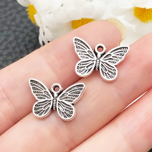Macro di due ciondoli a farfalla in argento vintage per gioielli fai da te