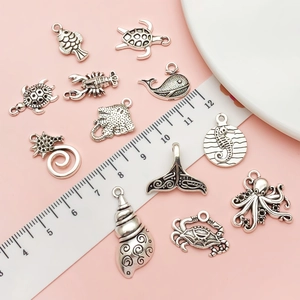 Antique silver ocean charms collection featuring sea turtles and octopuses on pink background