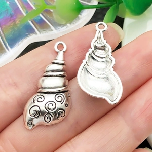 Detailed view of an antique silver seashell pendant with realistic spiral textures