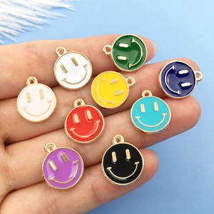 Colorful enamel smiley face charms for DIY jewelry making held in hand for size