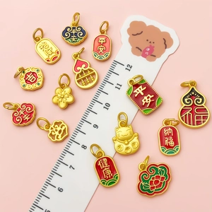 Macro shot of traditional Chinese enamel charms showing miniature sizes on a ruler