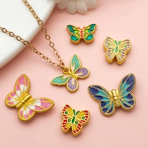 Detail van DIY gouden vlinderbedeltjes met kleurrijk emaille voor het maken van sieraden
