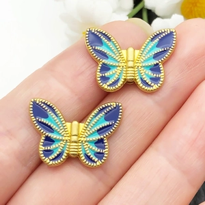 Detailopname van vergulde vlinderkralen van legering met blauw emaille inleg