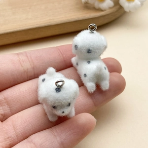 Close-up of white flocked dalmatian puppy charms with black spots and metal rings