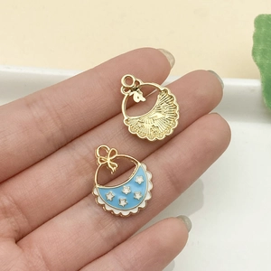 Primer plano de colgante de ropa de bebé esmaltada azul y dije de estrella dorada DIY