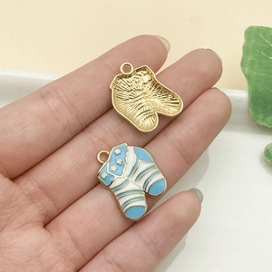 Detalle de los dijes de zapatillas en esmalte azul con acabado dorado y estrellas