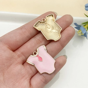 Detalle de colgantes de mameluco en esmalte rosa con reverso dorado para joyería de DIY
