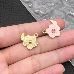 Detailed macro view of pink enamel cherry blossom pendants with zircon and wings