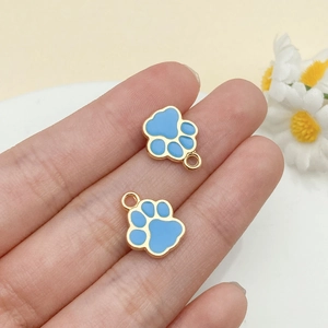 Détail des breloques pattes en émail bleu ciel avec bordure dorée pour bijoux DIY