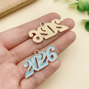 Detalle de colgantes año 2026 con acabado dorado texturizado y esmalte azul claro