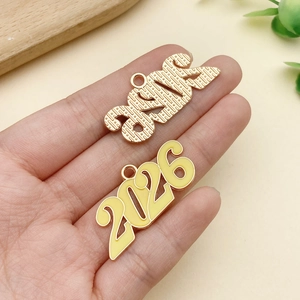 Primer plano de dijes de metal dorado 2026 con acabado de esmalte amarillo para joyas