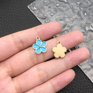 Detail of blue enamel flower pendant with gold plated textured back and hanging loop