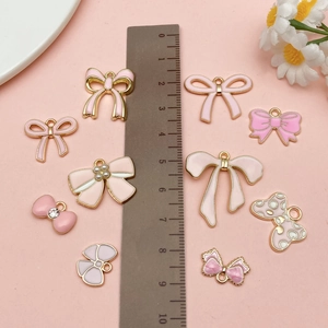 Detail view of pink and gold enamel bow charms for DIY jewelry and crafts