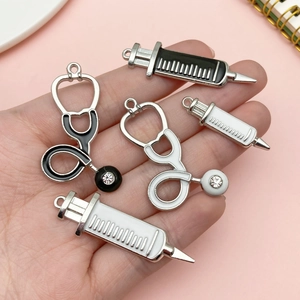 DIY medical alloy charms set featuring white and black enamel stethoscope and syringe pendants