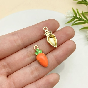 Gros plan de pendentifs carotte en alliage avec émail orange et dos en métal doré